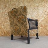 Old armchair upholstered in velvet, carved and caned wood