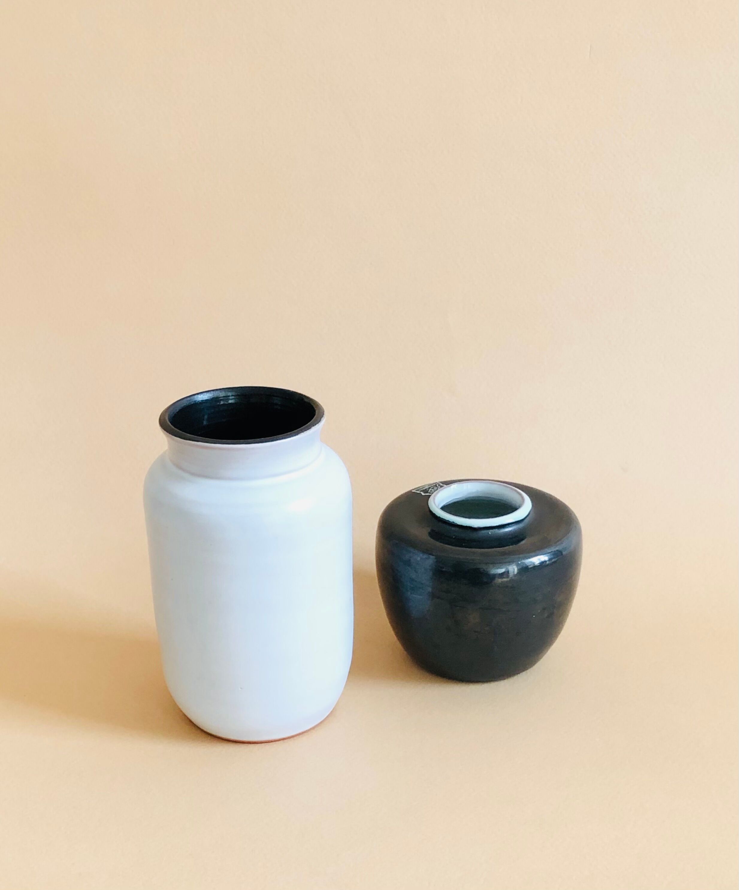 Duo of small black and white ceramic vases