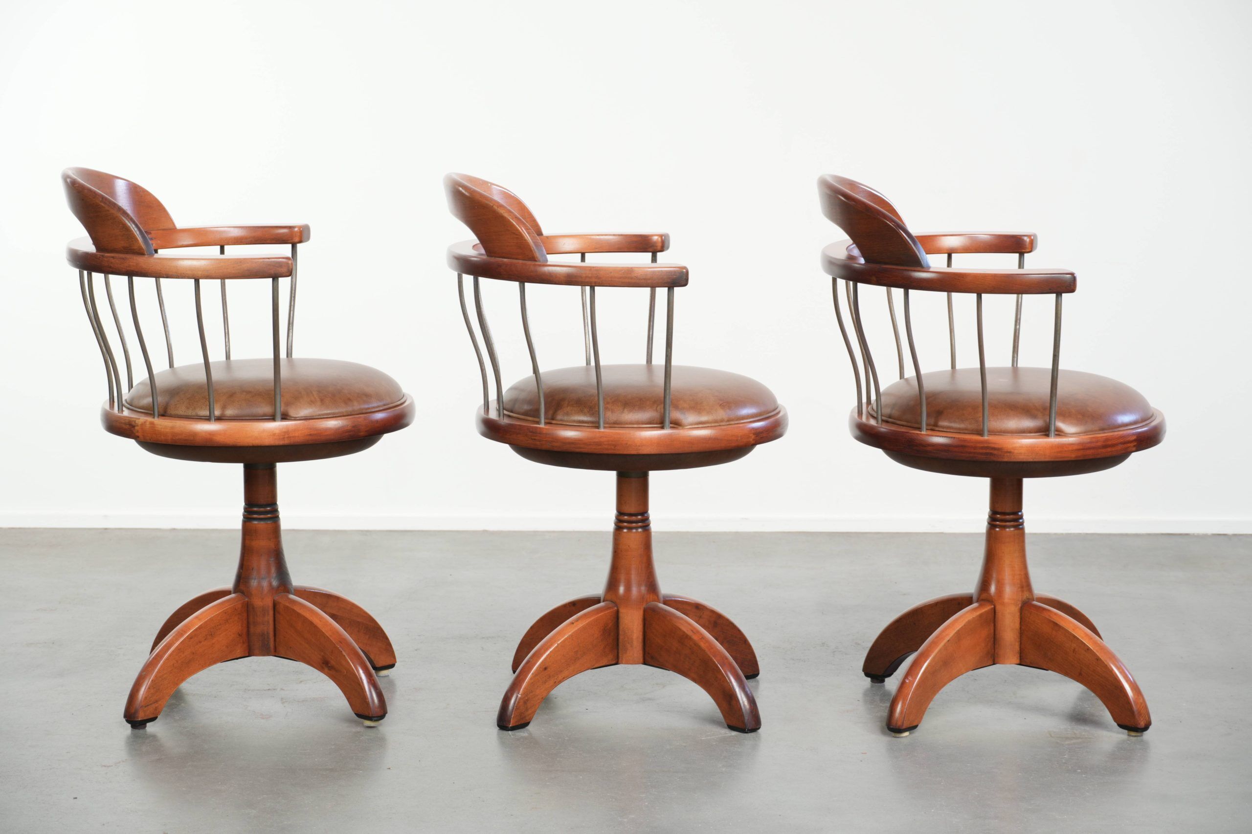 Ensemble de 3 chaises de bureau / de côté pivotantes avec un siège en cuir de vache couleur cognac.