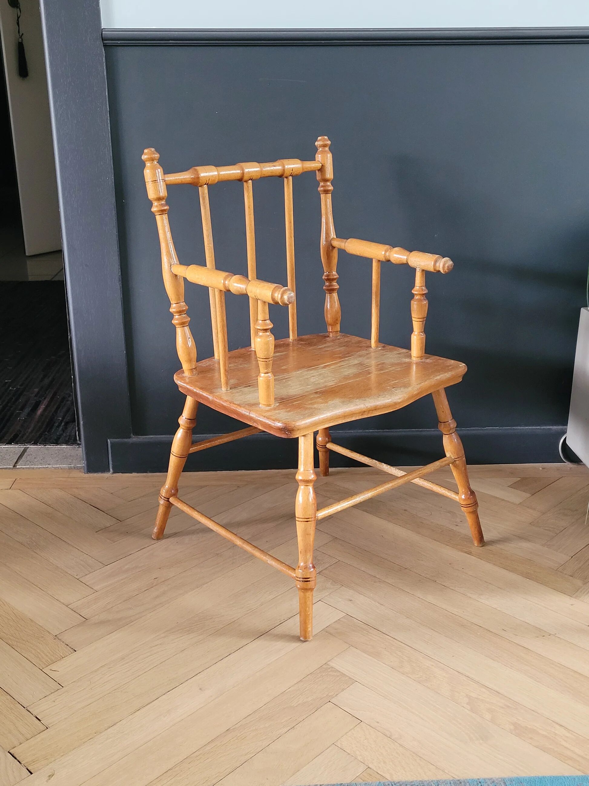 Antique wooden child's armchair from the early 20th century.