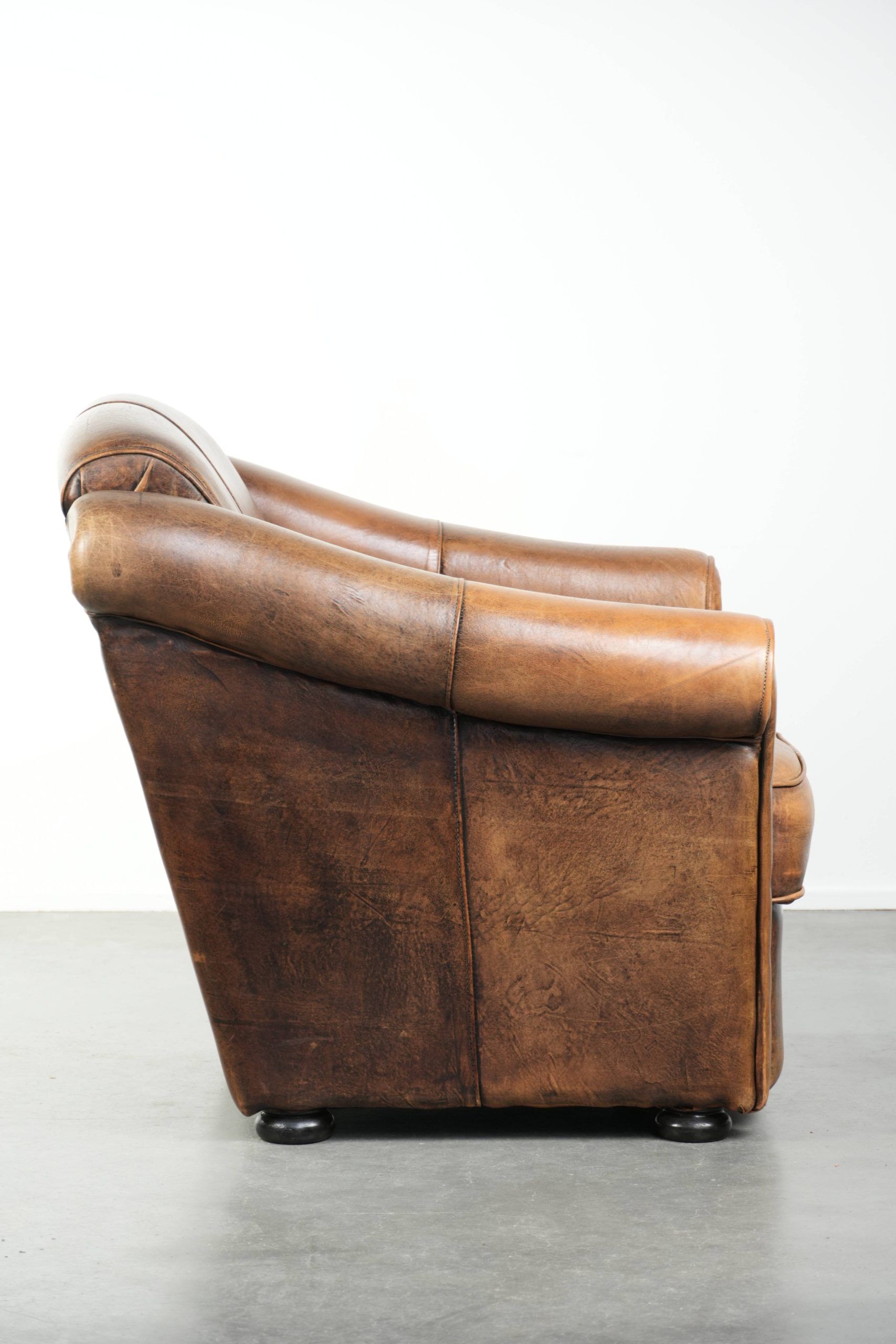 Fauteuil en peau de mouton magnifiquement conçu et confortable, avec un look intemporel et une finition de passepoil assortie.