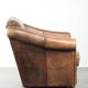 Fauteuil en peau de mouton magnifiquement conçu et confortable, avec un look intemporel et une finition de passepoil assortie.