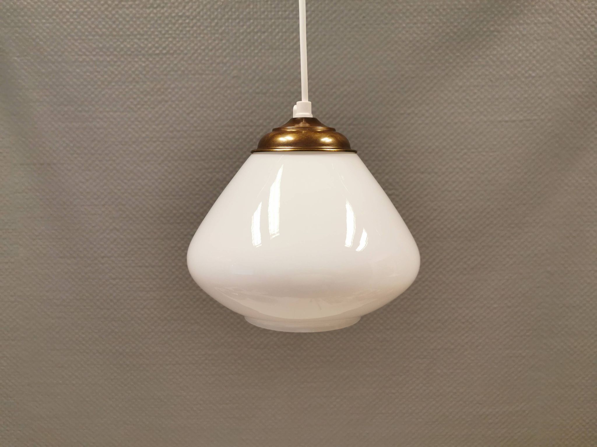Beautiful ball-shaped hanging lamp in white opal glass with brass top.