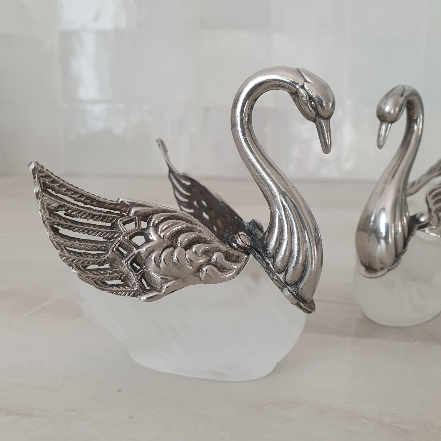 Two frosted glass swan salt cellars with silver plating.