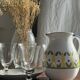 Large white terracotta carafe with a stylized green and yellow frieze pattern