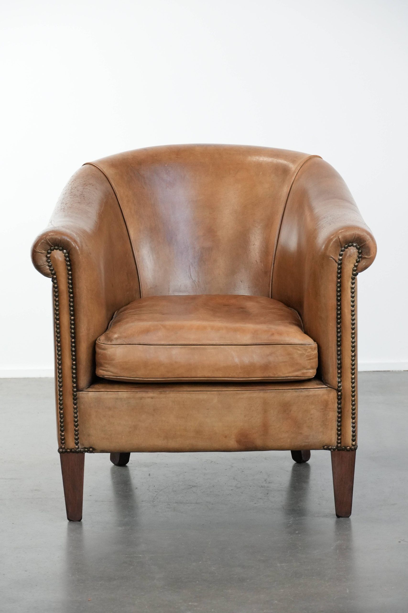 Characterful club chair made of sheepskin leather with light cognac colours