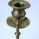Brass candle holder with flowers and round shape.