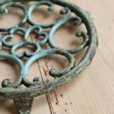 Antique round turquoise cast iron trivet.