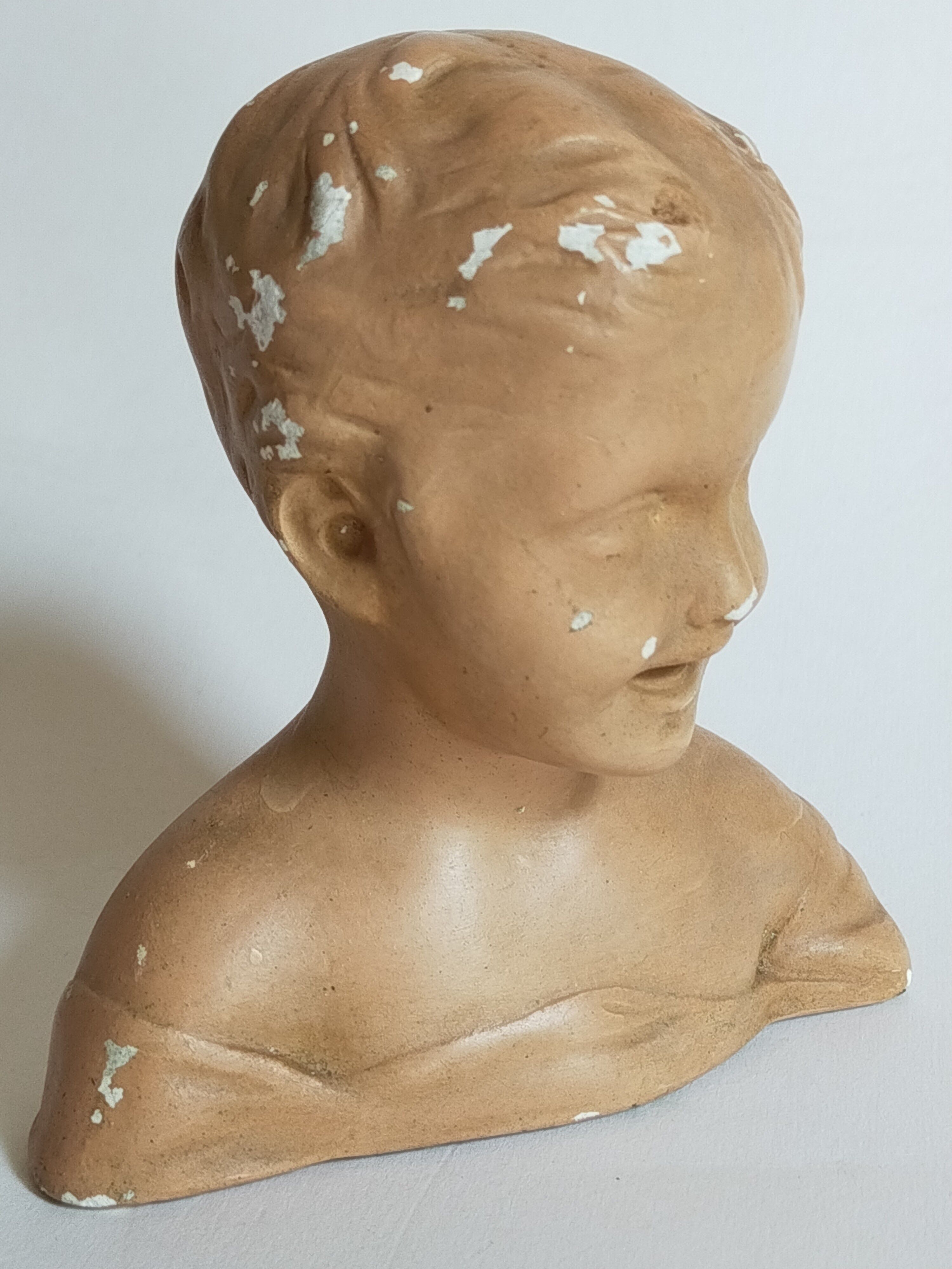 Bust of a small child in ancient plaster