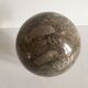 Marble ball paperweight on vintage brass