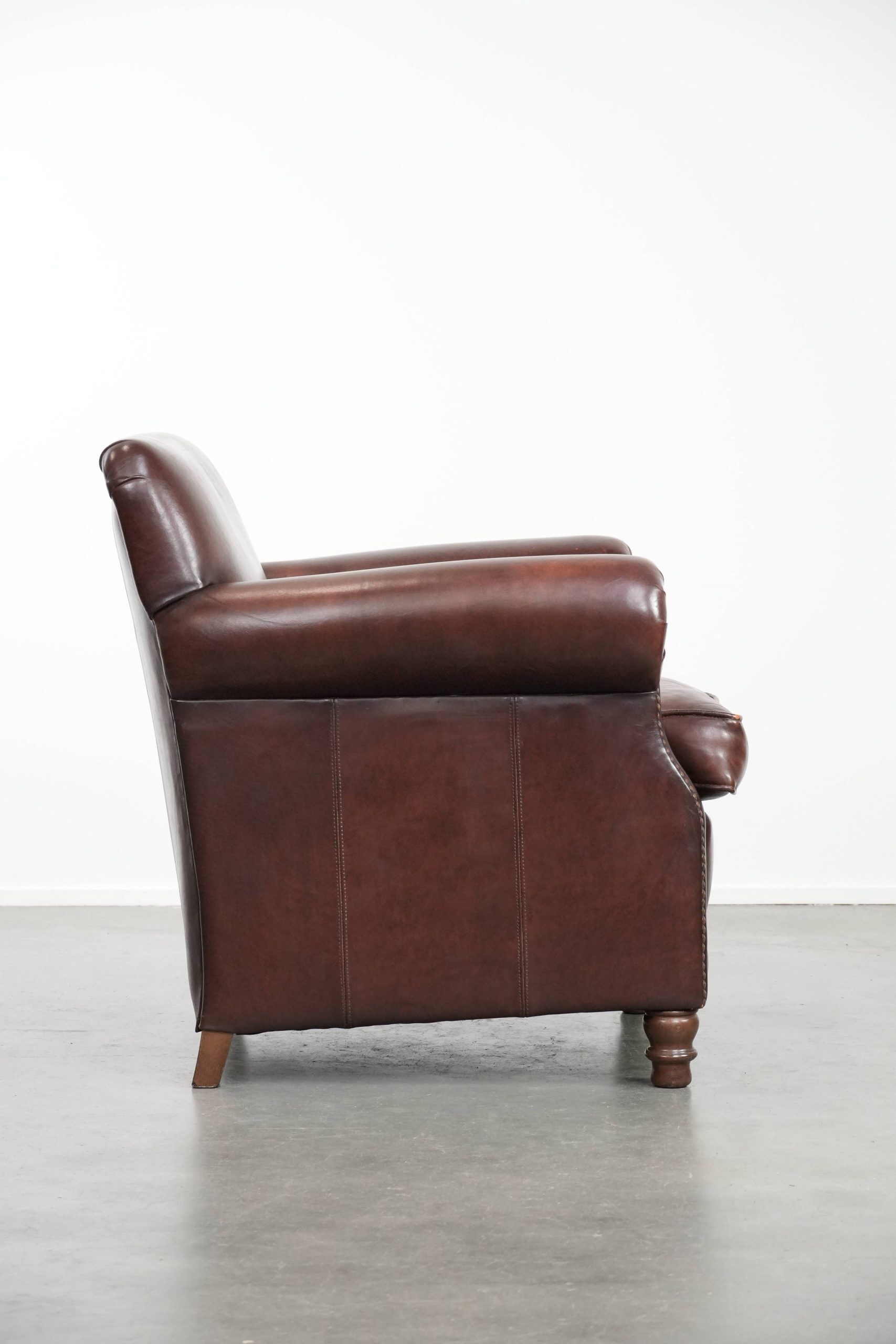 Sheepskin armchair with a classic finish and decorative studs.