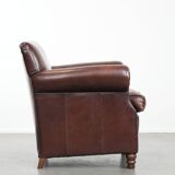 Sheepskin armchair with a classic finish and decorative studs.