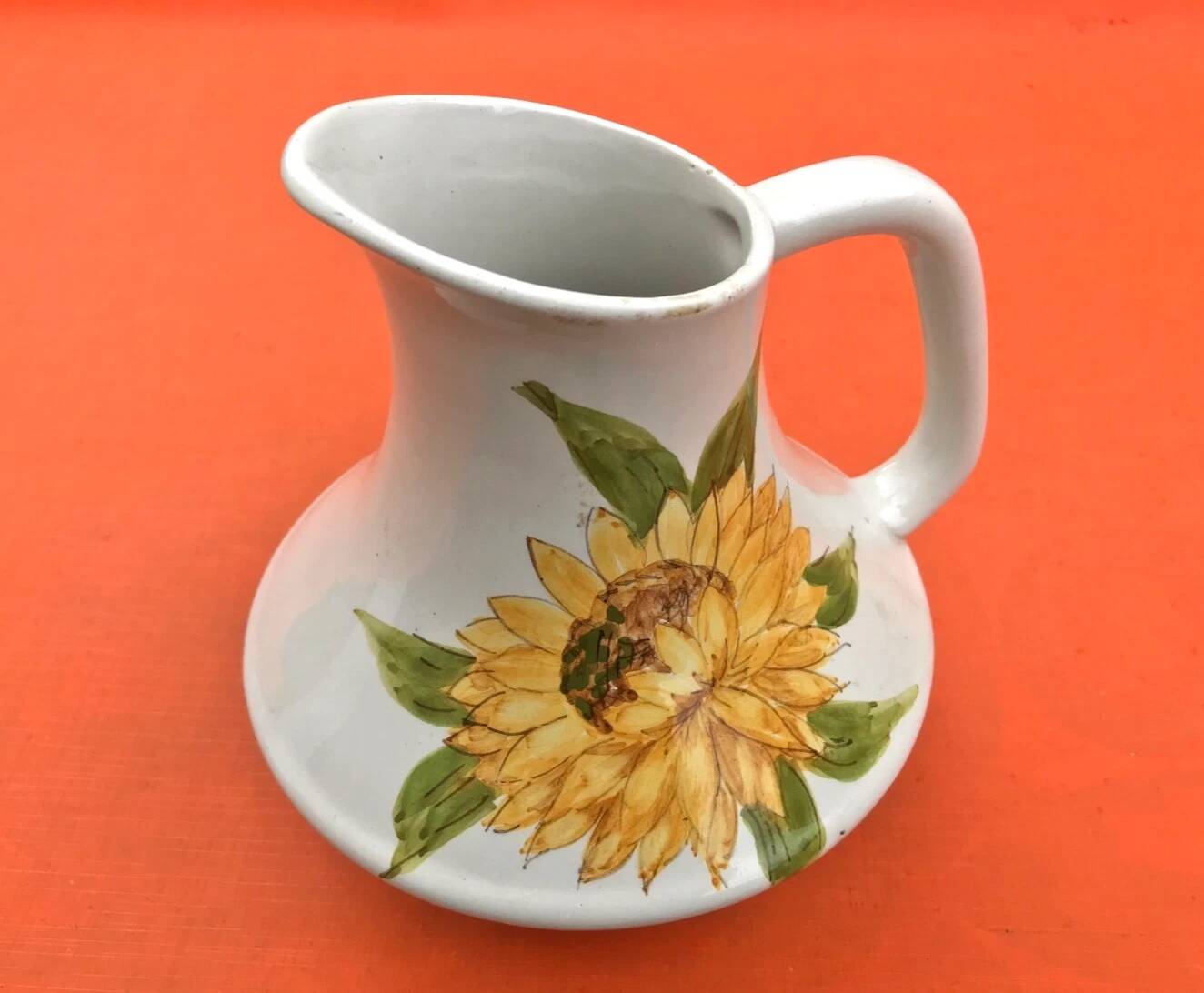 Antique glazed ceramic pitcher with sunflower decoration