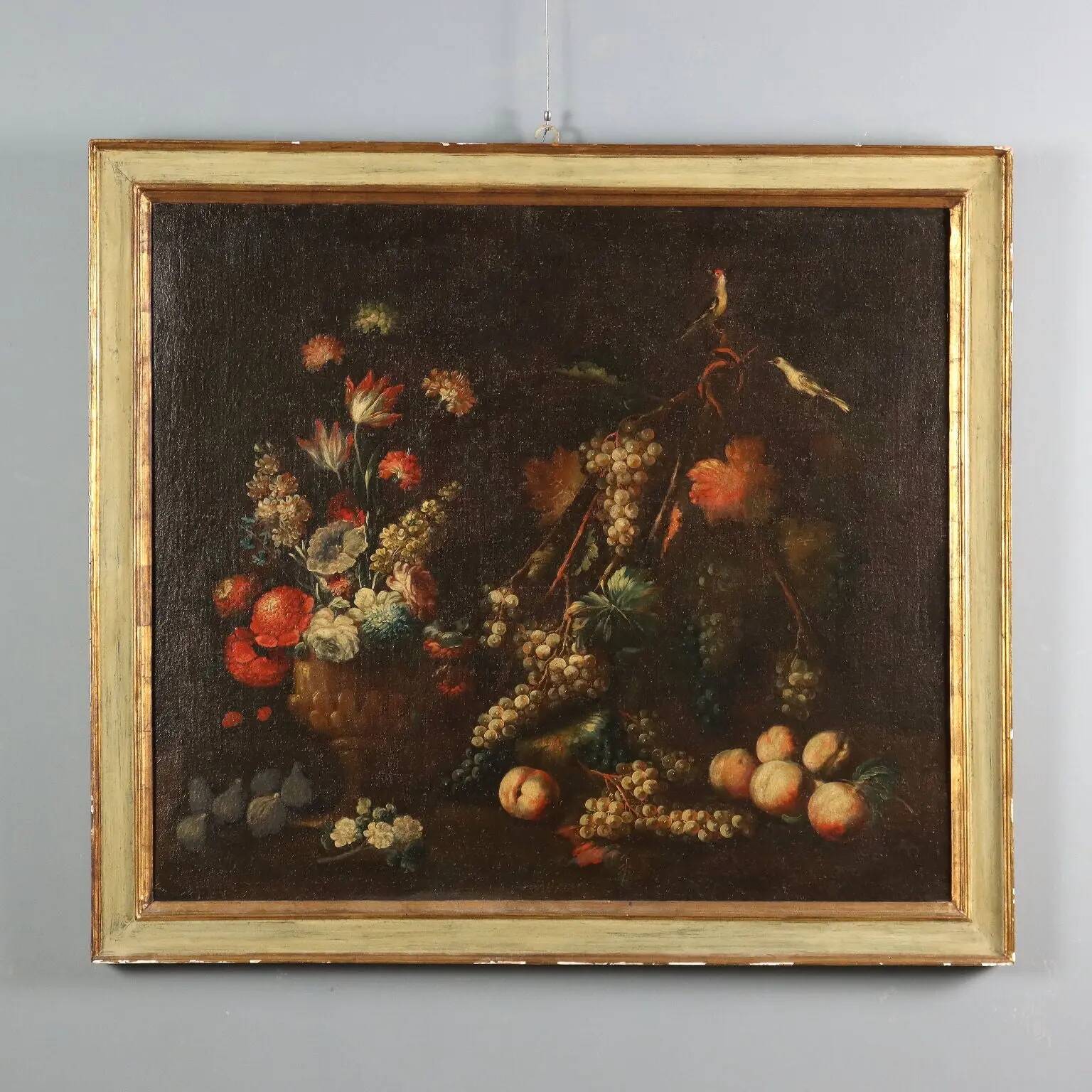 Old painting of still life with flowers, fruits, and birds from the 18th century.