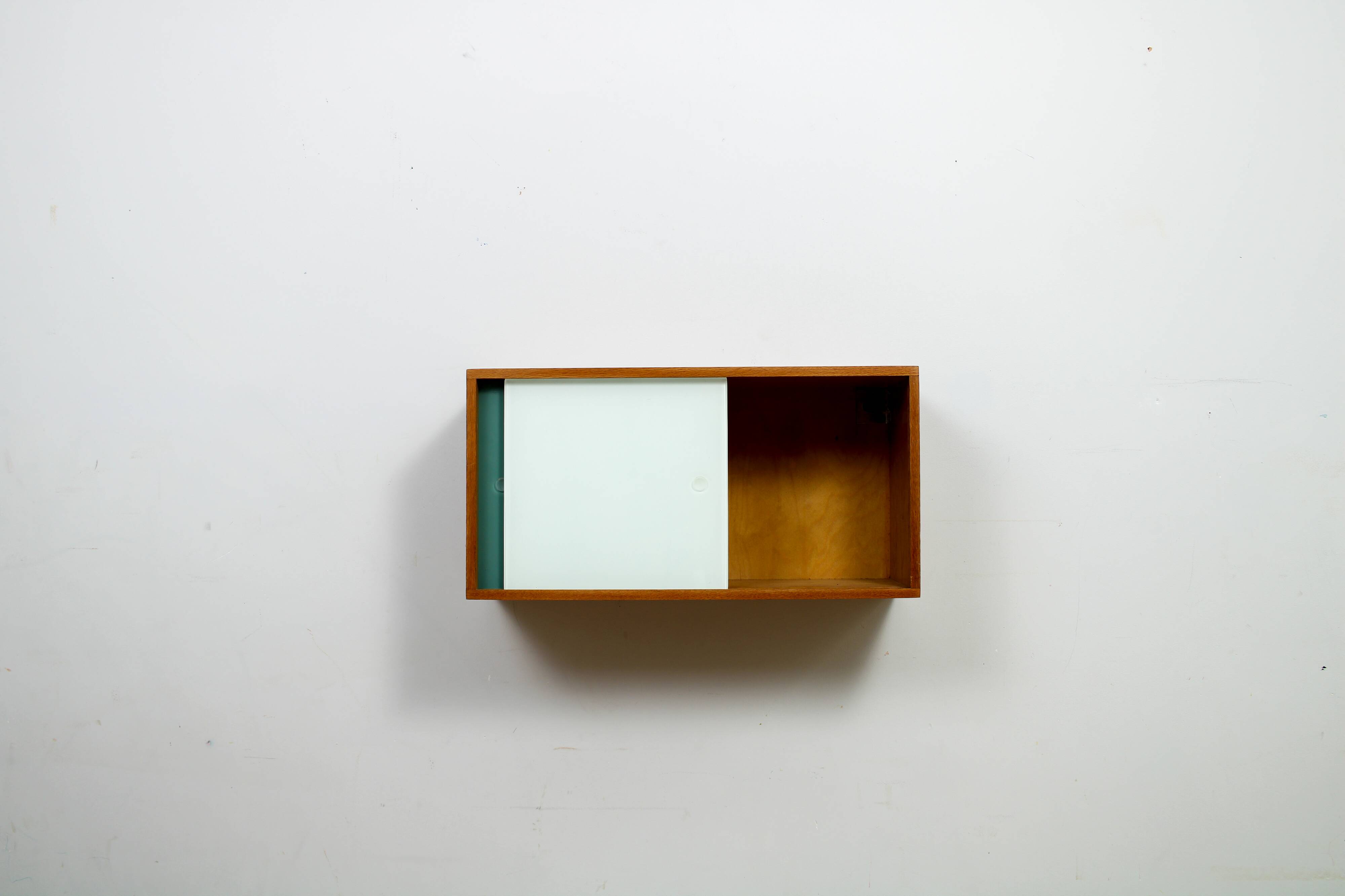 A vintage mid-century wall hung oak cabinet, green & white glass doors