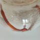 Red-orange glazed ceramic workshop bowl with floral decoration.