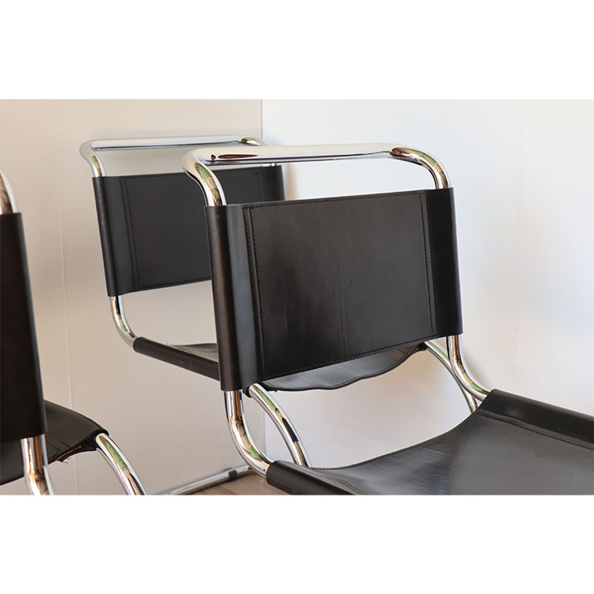 Series of 6 minimalist chairs in chrome metal and black leather around 1970