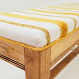 Vintage oak bench with striped linen fabric in a country style.