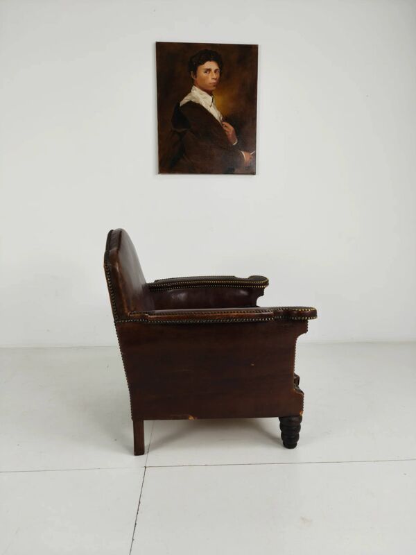 Fauteuil club en cuir ancien avec détails cloutés