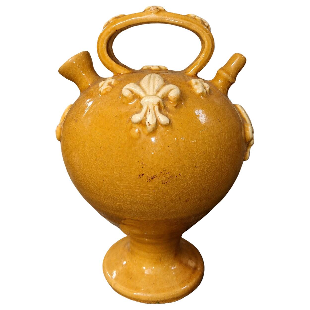 Glazed terracotta gargoyle decorated with fleur-de-lis.