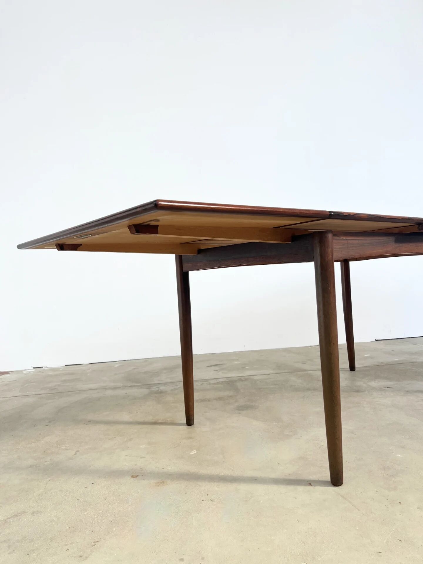 Rosewood dining table with integrated extensions — Denmark, 1960s