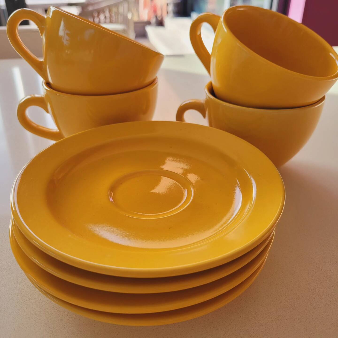 4 yellow cups and saucers