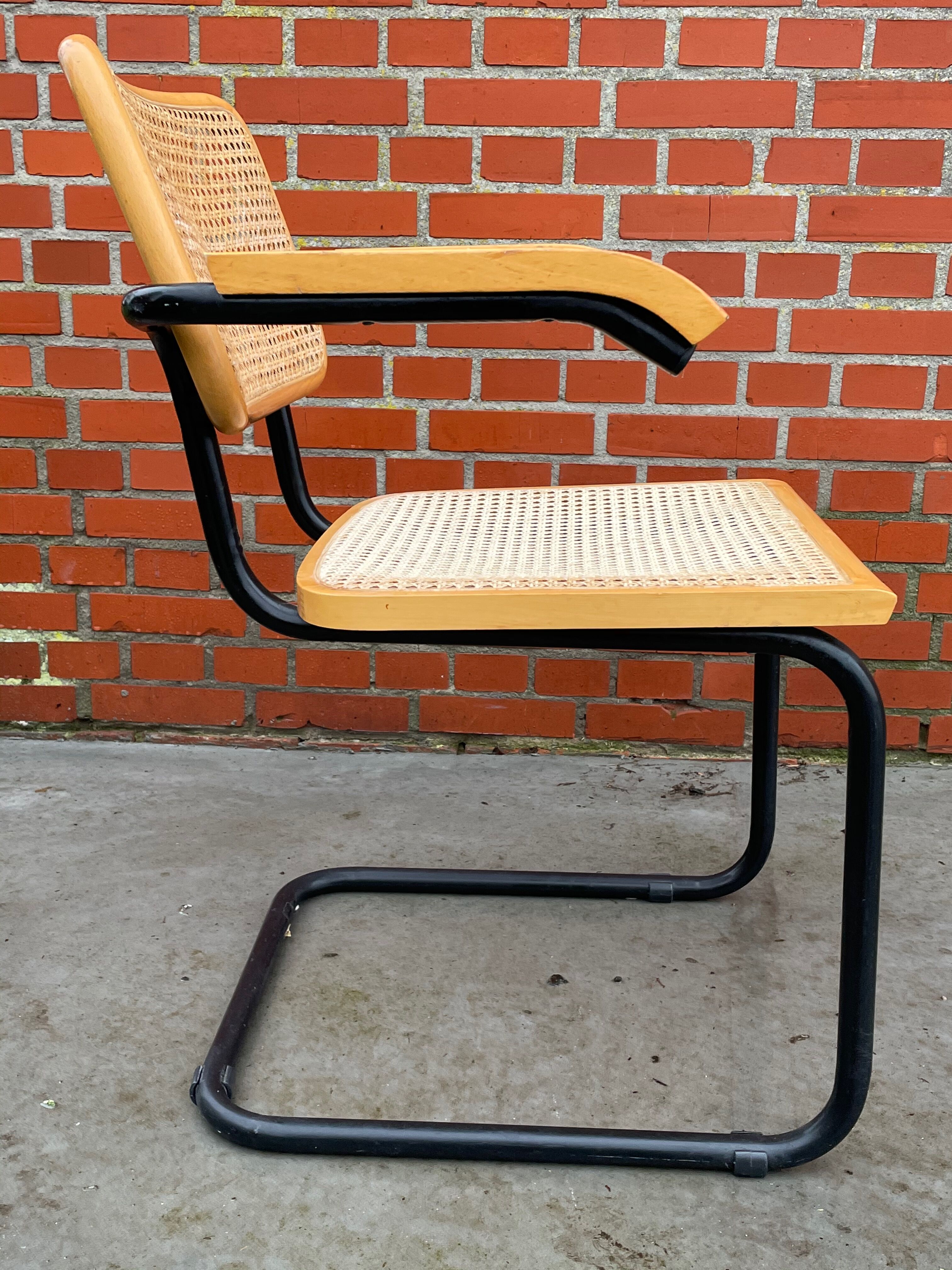 Chaise modèle Cesca conçue par Marcel Breuer avec accoudoirs à structure noire
