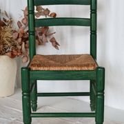Vintage children's chair in green wood with a woven straw seat