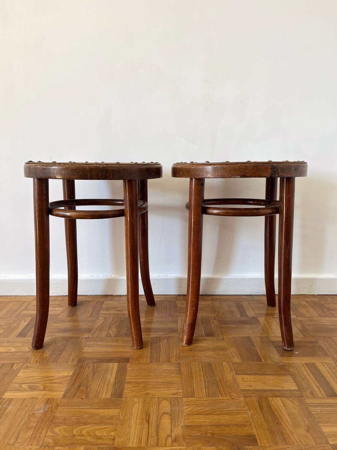 2 antique bistro stools with curved wood and caning effect.