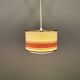 Hanging lamp with brass-coloured details, made of fabric with intact plastic bottom grille.