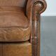 Fauteuil à oreilles de style anglais couleur cognac en cuir de vache.