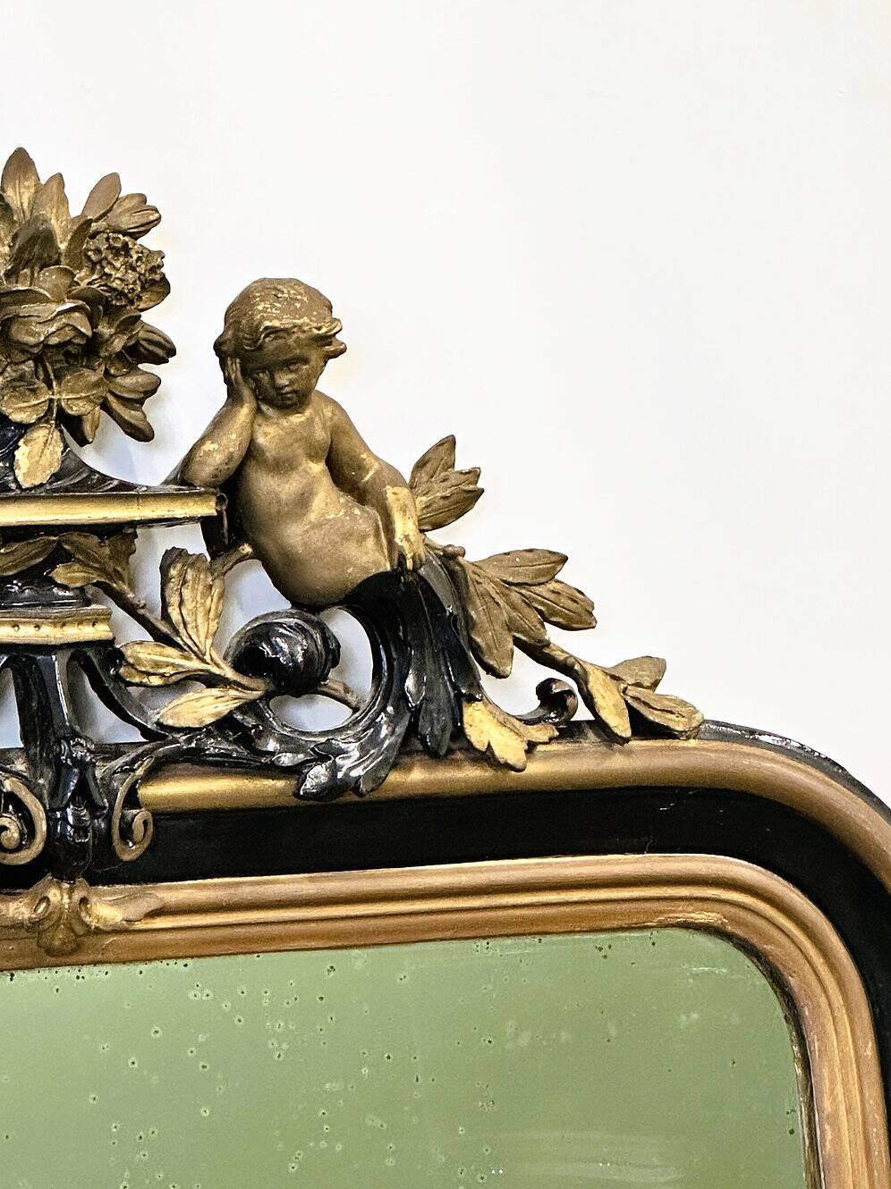 Antique 1800s black and gold mirror with cupid, France 1800s.