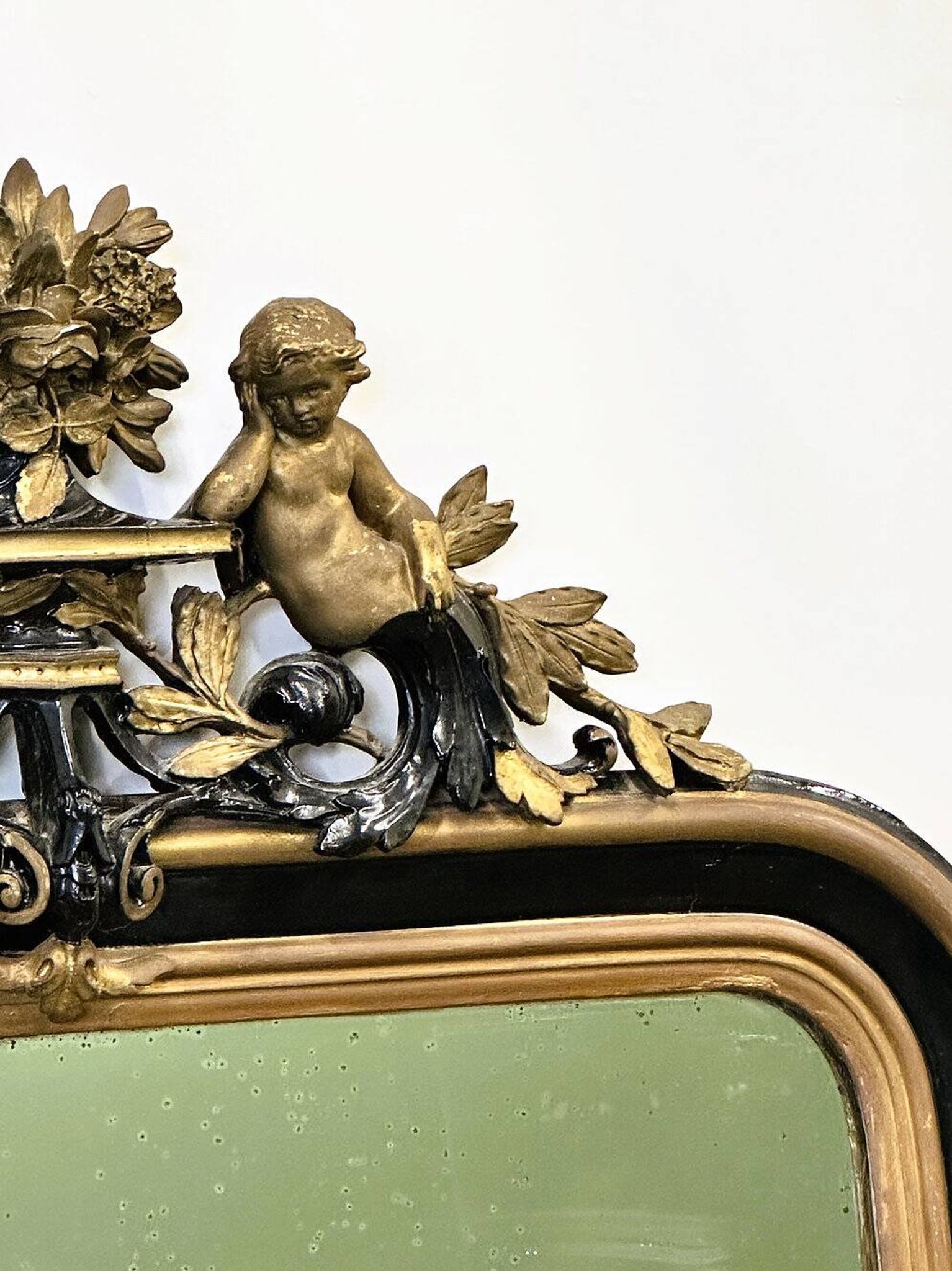 Antique 1800s black and gold mirror with cupid, France 1800s.