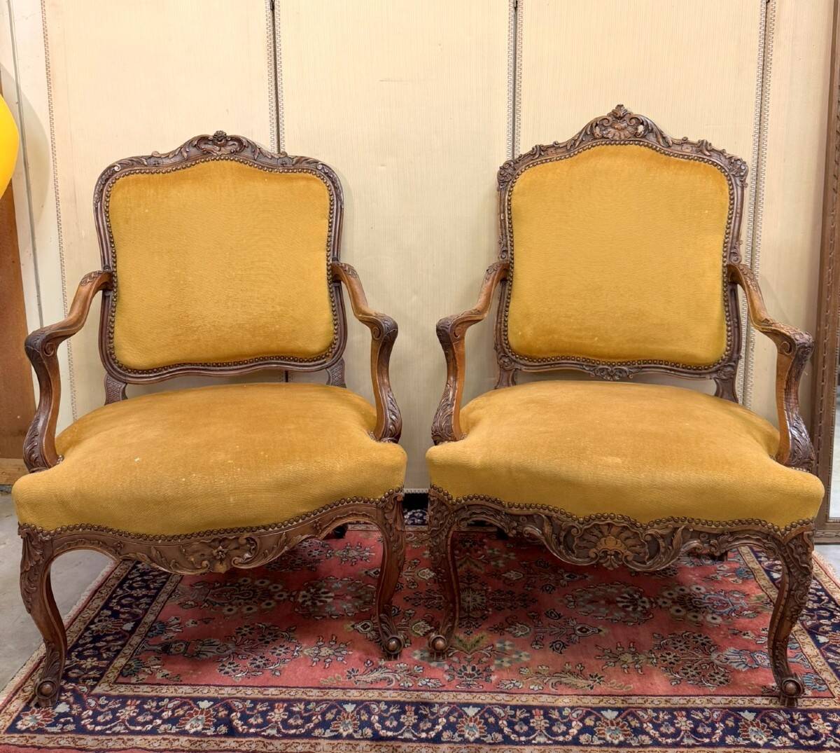 Pair of faux Louis XV armchairs in fully carved walnut