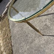 Round coffee table in gilded brass with a transparent glass top, 1960s design.