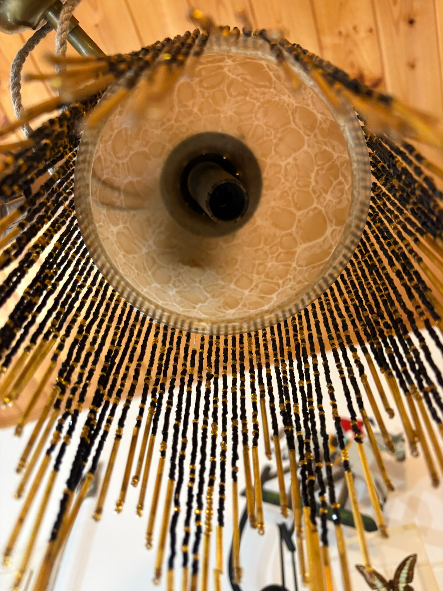 Wall lamp with marbled glass shade and beaded fringe in Art Nouveau style.