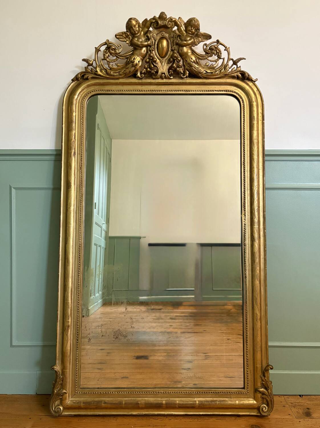 Louis Philippe mirror with a pediment featuring winged putti.