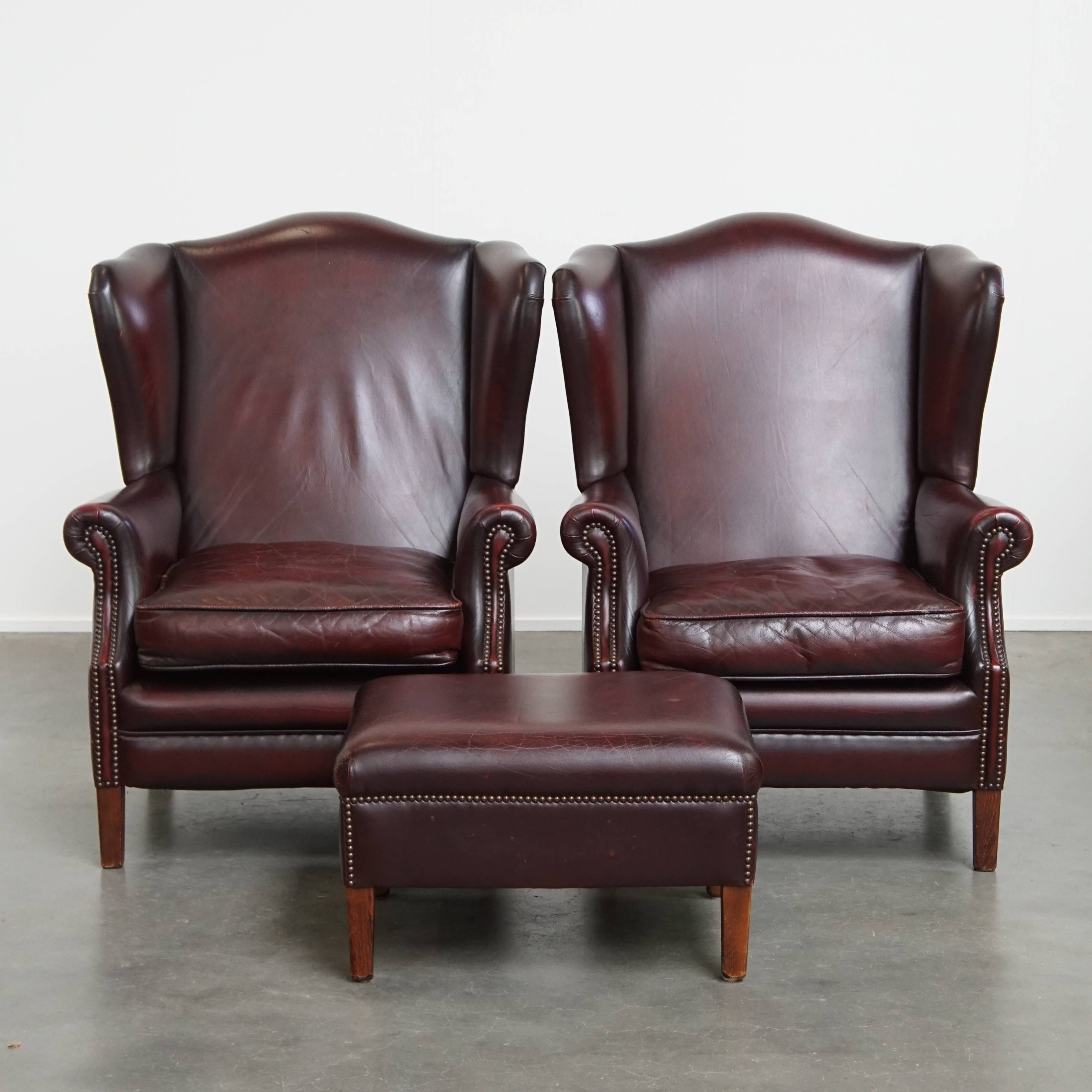 Ensemble de 2 fauteuils à oreilles en cuir de vachette + pouf de style anglais