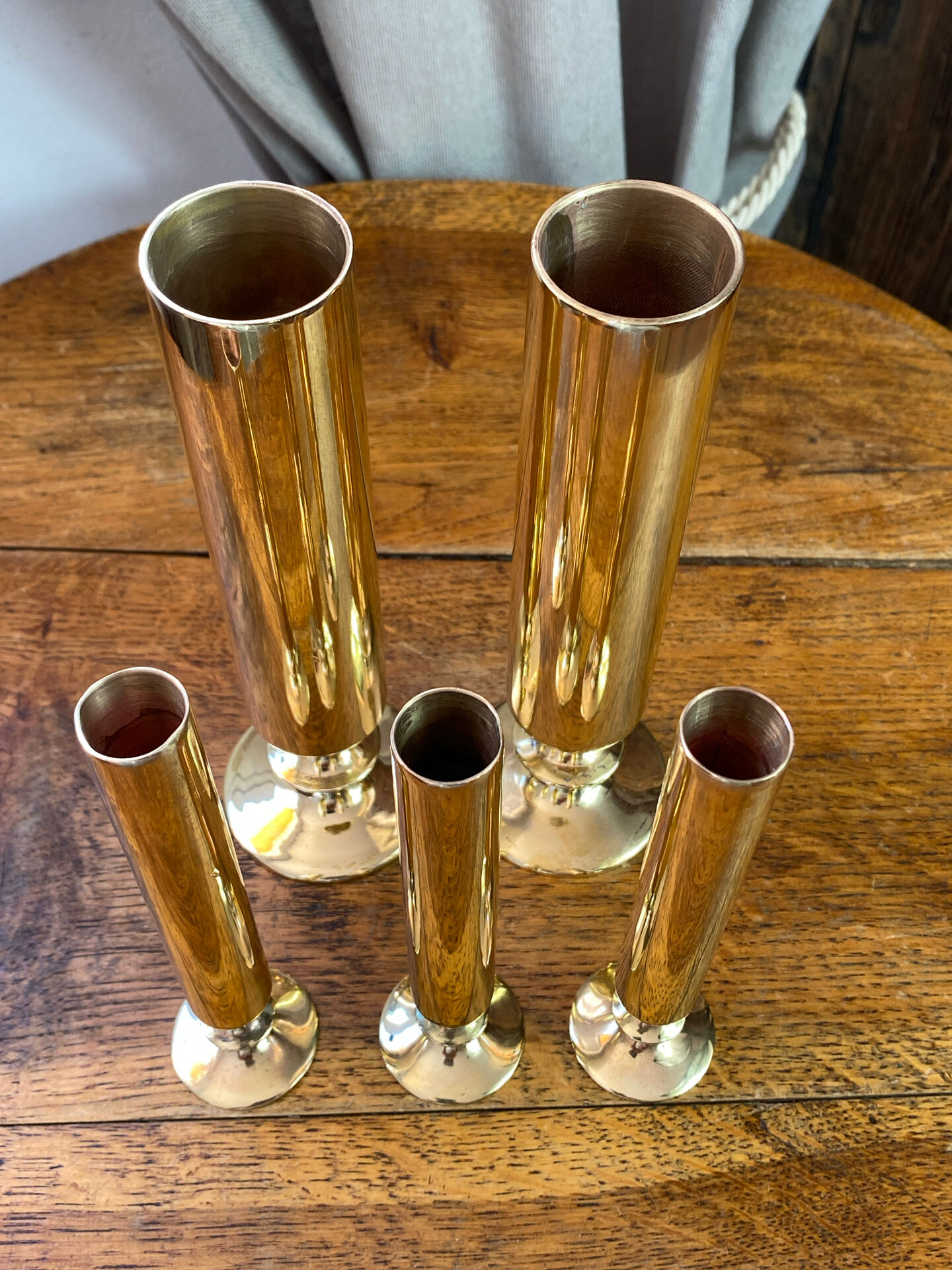 Set of candlesticks and tubular vases in solid brass.