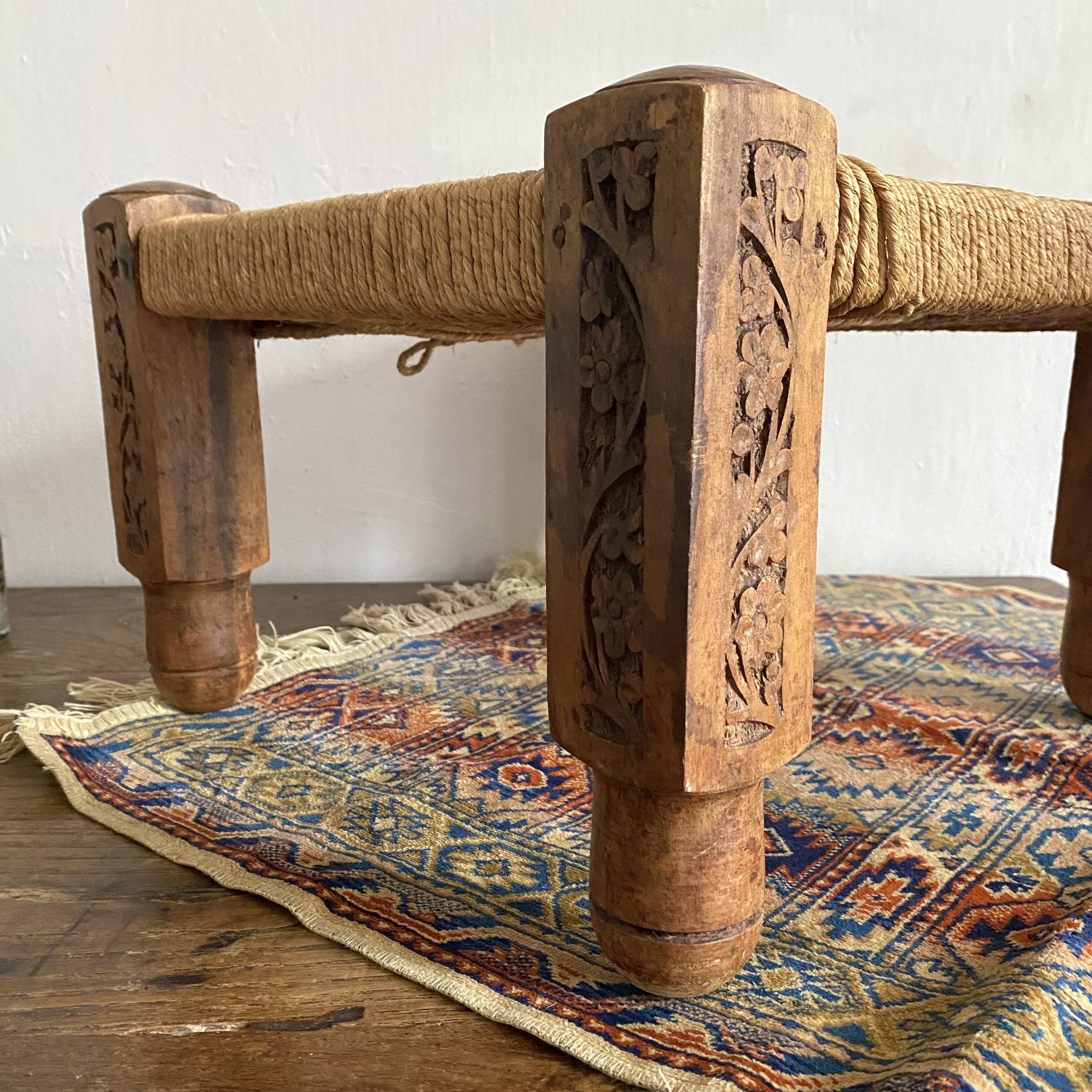 Low stool with carved wood and braided cord.