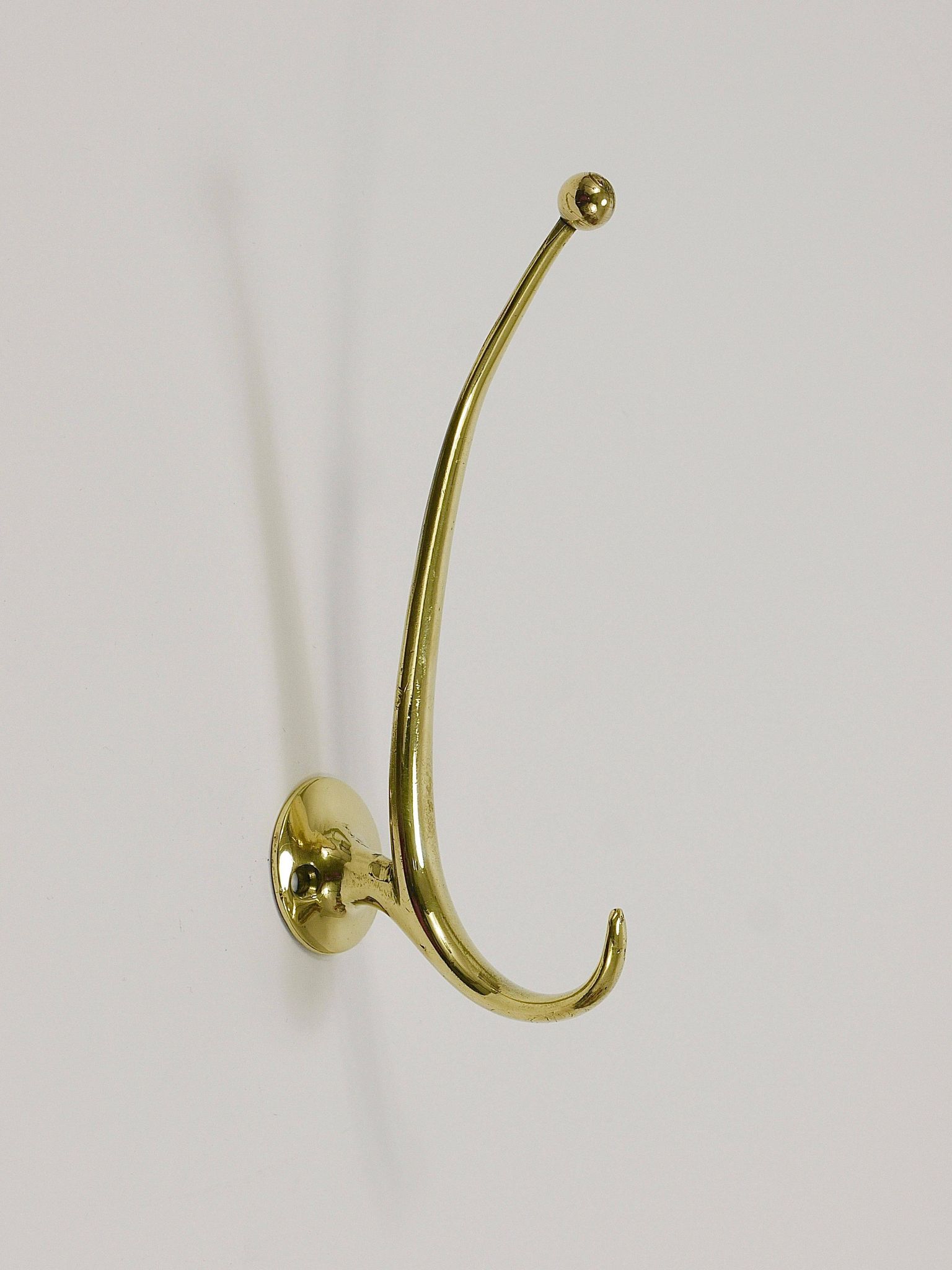 Two curved wall coat racks in brass by Franz Hagenauer, Vienna, mid-20th century, 1950s.