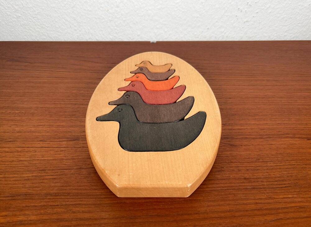 Vintage wooden puzzle with duck figurines.