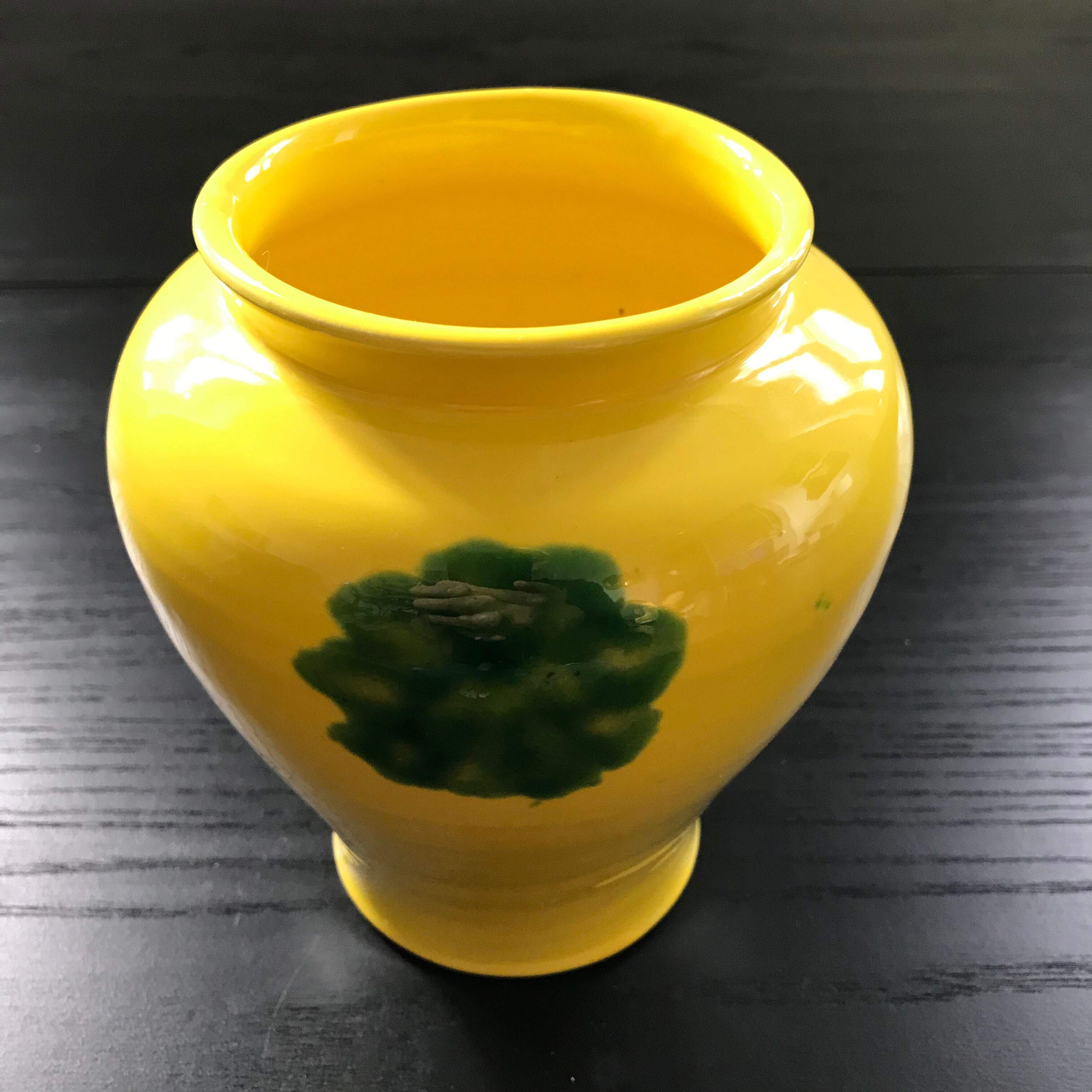 Yellow vase with green spots.