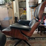 Black leather Eames Vitra armchair, original with rosewood ottoman.