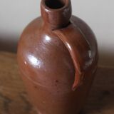 Vintage stoneware liqueur bottle with handle and spout.