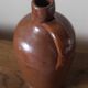 Vintage stoneware liqueur bottle with handle and spout.