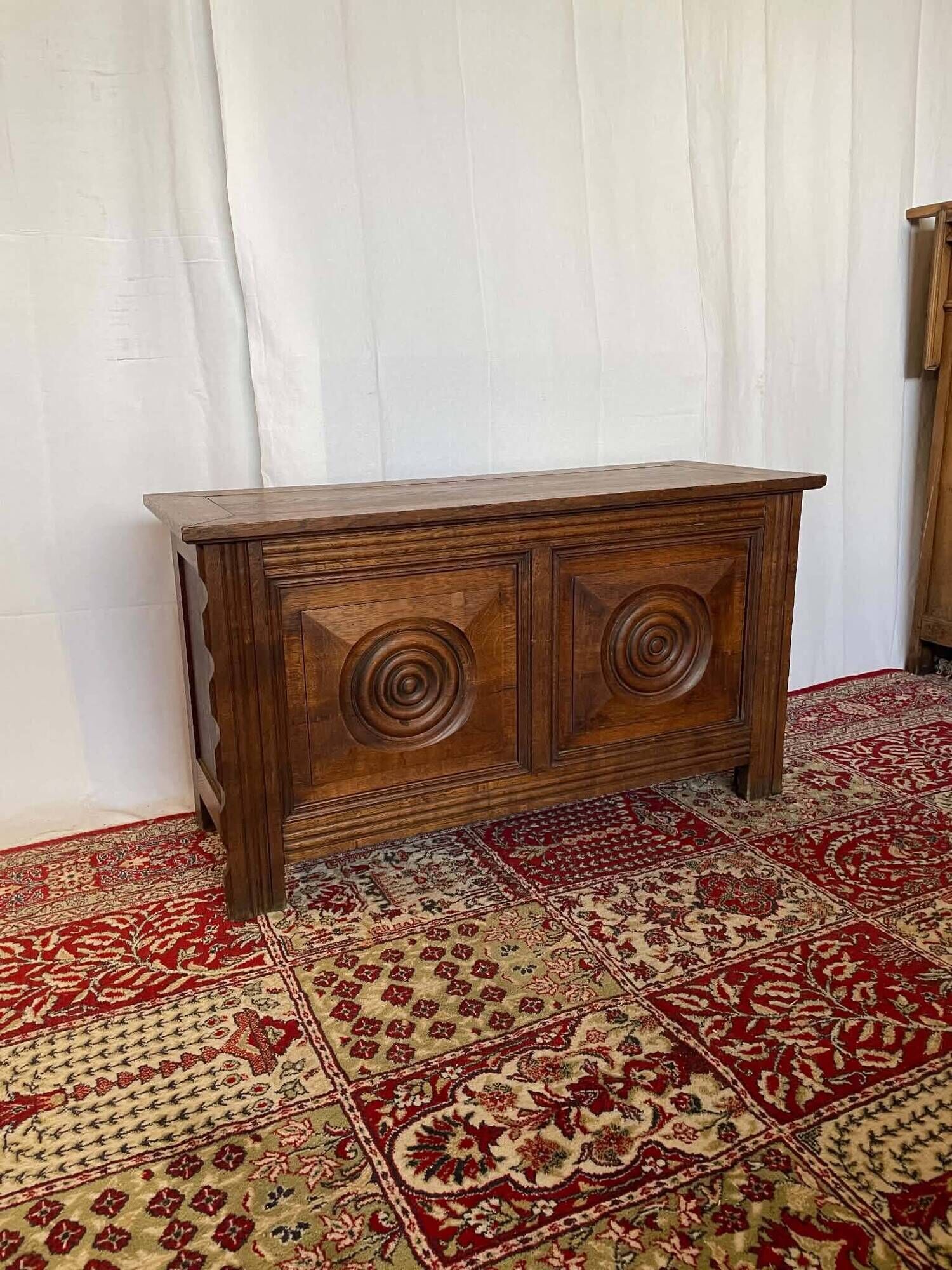 Small antique oak chest with carved panels.