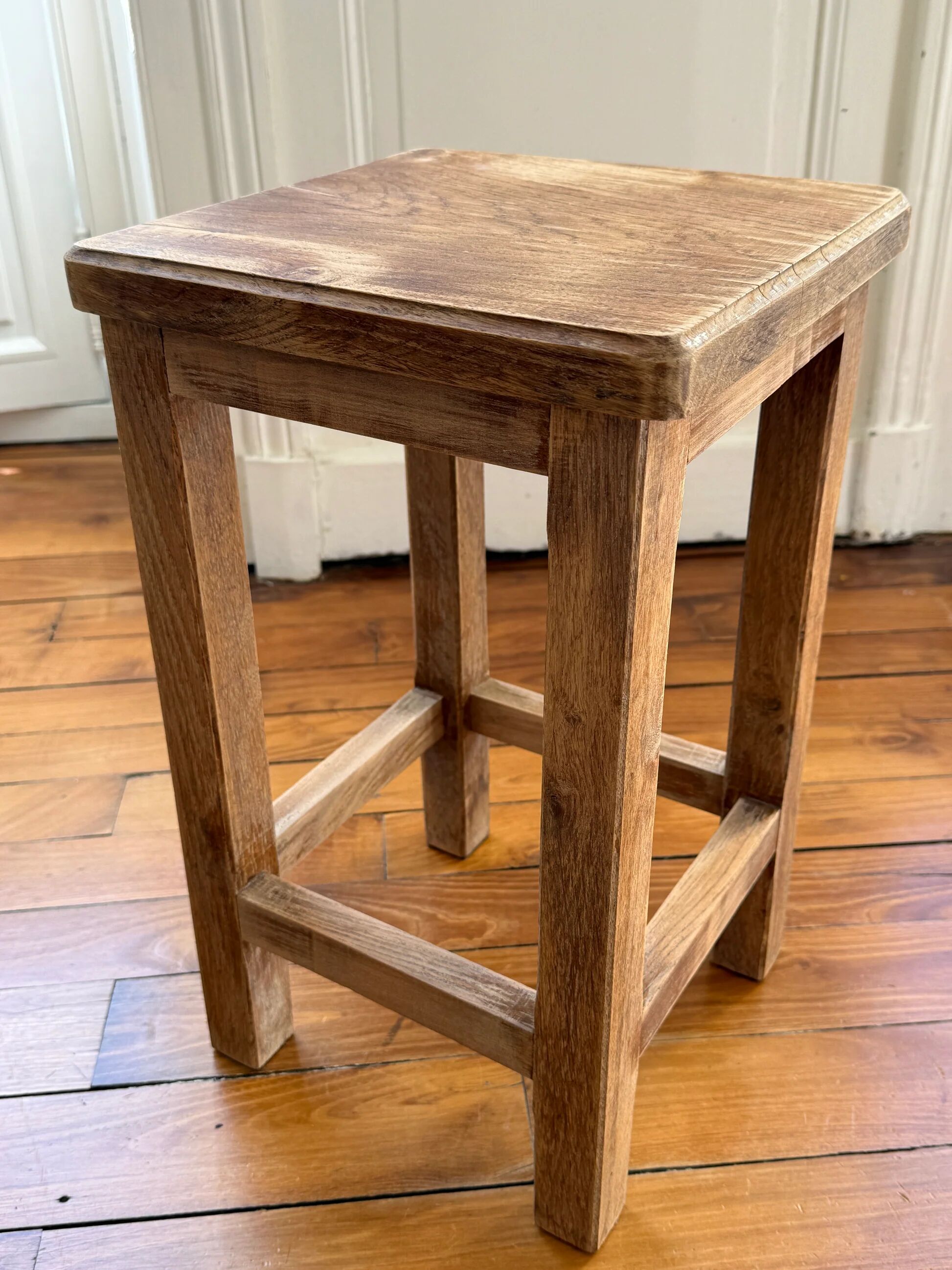 Brutalist stool in raw wood with a weathered effect.