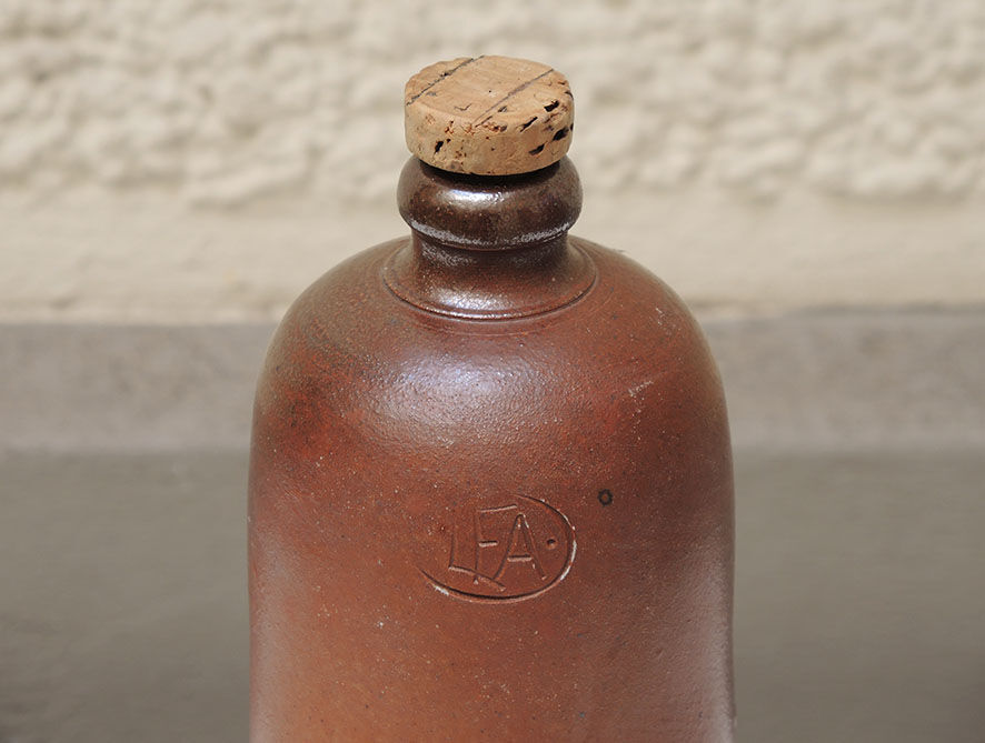 Old enamelled brown sandstone bottle with cork stopper