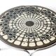 Black and white round coffee table with a mandala top and chrome metal base.